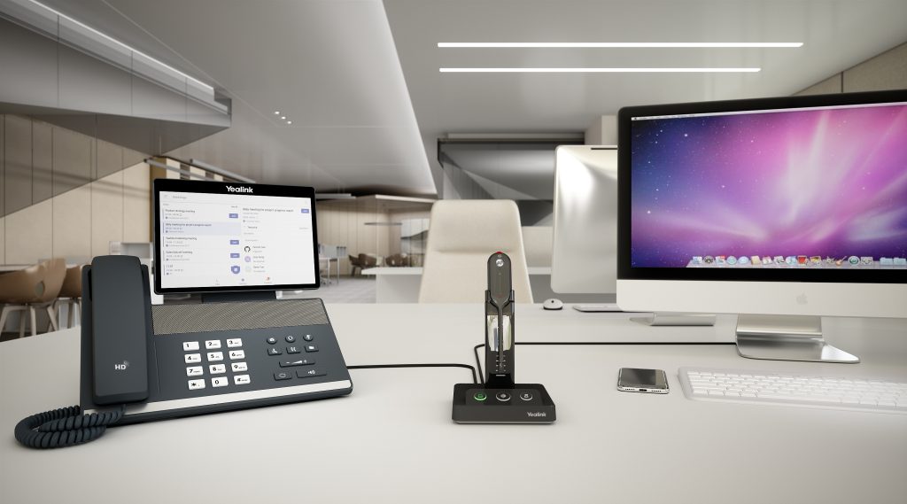 Yealink devices sitting on top of modern office desk.